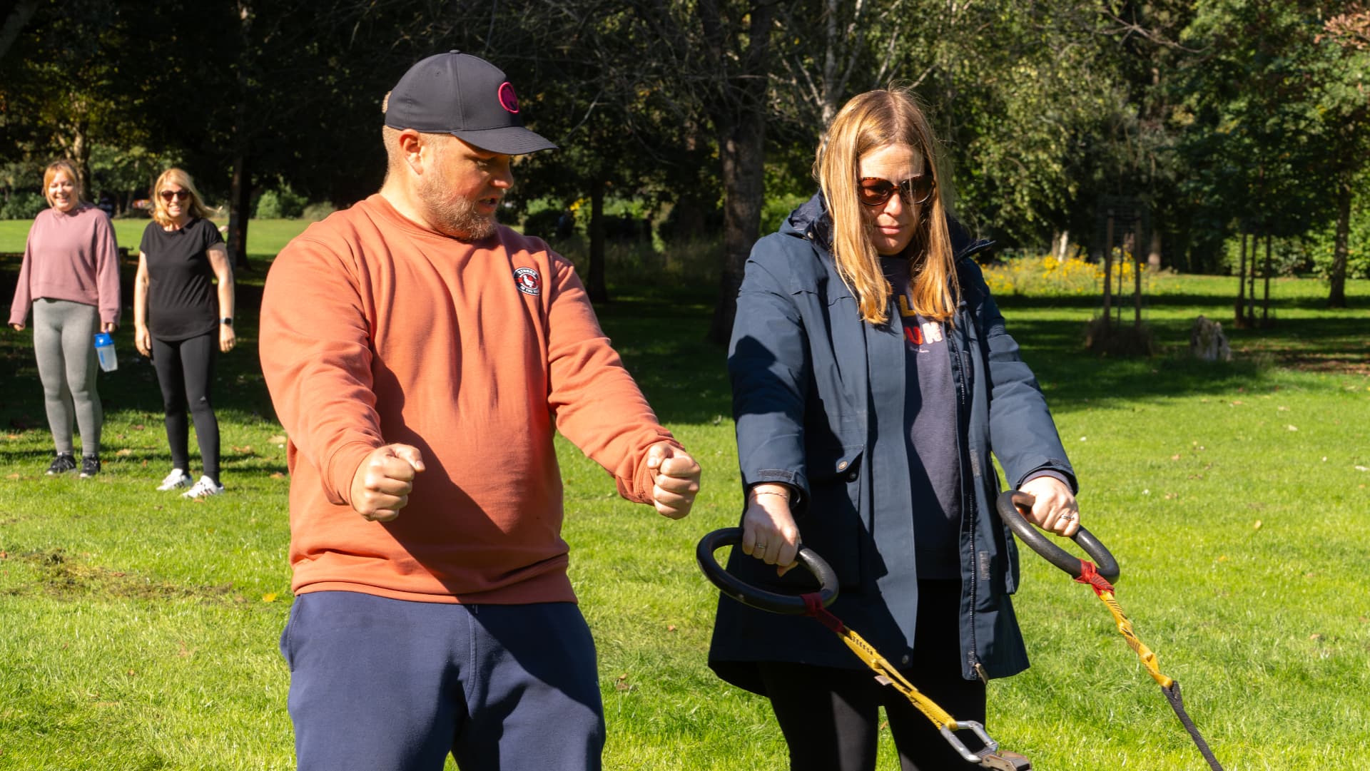 A coach guiding a member through a sled exercise